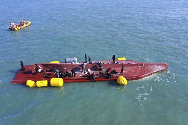 Anggota tim penyelamat mencari orang-orang dari kapal yang terbalik di perairan Korea Selatan, Minggu, 5 Februari 2023.  Foto: Jung Hee-sung/Yonhap via AP