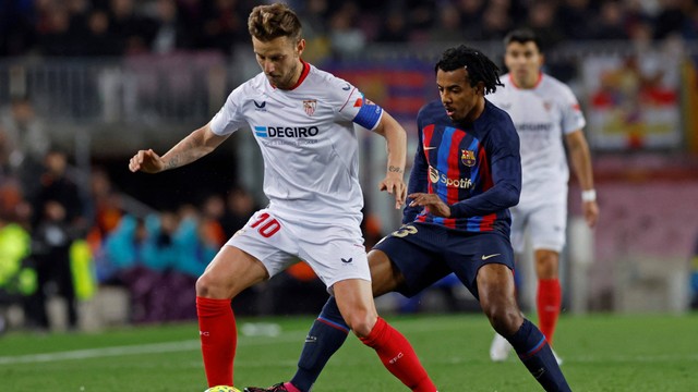 Ivan Rakitic (kiri) duel dengan Jules Kounde di laga Barcelona vs Sevilla dalam lanjutan Liga Spanyol 2022/23 di Stadion Camp Nou, Senin (6/2/2023) dini hari WIB. Foto: REUTERS/Albert Gea