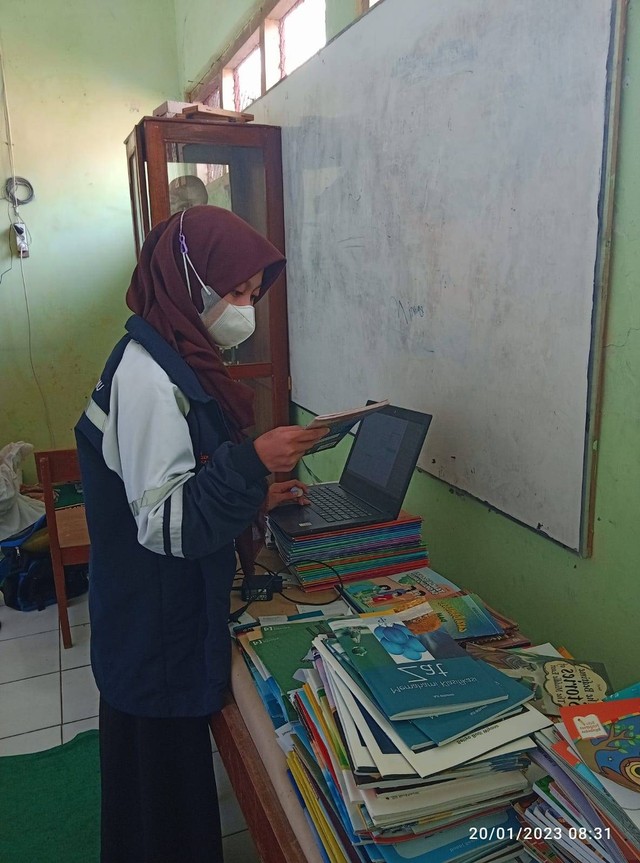 Mahasiswa KKN UNDIP Tim 1 tengah melakukan inventarisasi digital koleksi bahan pustaka di perpustakaan SDN 02 Kaligayam