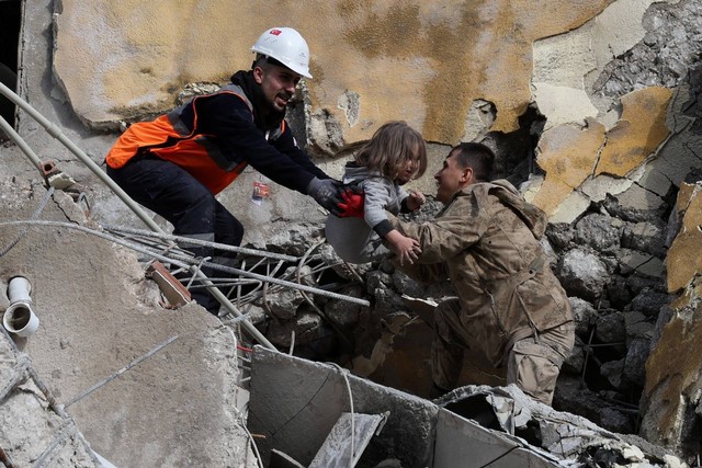 Tim penyelamat membawa seorang gadis dari bangunan yang runtuh setelah gempa bumi di Hatay, Turki. Foto: Umit Bektas/REUTERS