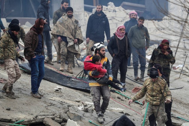 Tim penyelamat mengevakuasi seorang anak setelah gempa di kota Jandaris, Aleppo, Suriah.  Foto: Khalil Ashawi/REUTERS