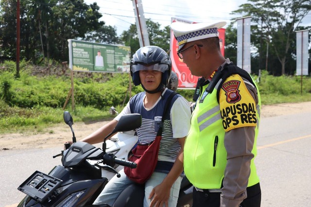 Kasat Lantas Polres Sekadau berbincang dengan pengendara saat dilakukan pemeriksaan kendaraan dalam Operasi Keselamatan Kapuas 2023. Foto: Dok. Humas Polres Sekadau