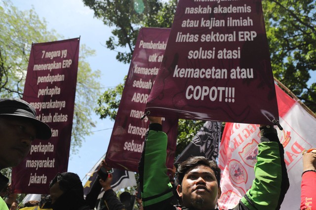 Massa ojek online membawa spanduk saat berunjuk rasa menolak sistem ERP di depan Balai Kota DKI Jakarta, Rabu (8/2/2023). Foto: Jamal Ramadhan/kumparan