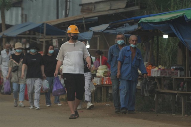 Sejumlah Tenaga Kerja Asing (TKA) berjalan di pasar yang berada di depan sebuah perusahaan smelter, Kecamatan Morosi, Konawe, Sulawesi Tenggara, Rabu (8/2/2023).  Foto: Jojon/ANTARA FOTO