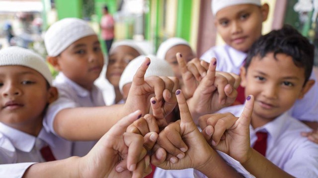 Siswa SD menunjukkan noda tinta usai divaksin polio. Foto: Suparta/acehkini