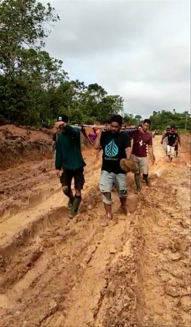 Warga Desa Semabi, Kalbar, menandu orang sakit melewati jalan yang rusak. Foto: Dok. Istimewa