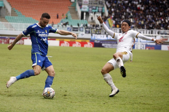 Pemain Persib Bandung Marc Klok (kiri) menguasai bola dikawal ketat pemain PSM Makassar Kenzo Nambu (kanan) dalam lanjutan BRI Liga 1 di Stadion Pakansari, Kabupaten Bogor, Jawa Barat, Selasa (14/2/2023).  Foto: Yulius Satria Wijaya/ANTARA FOTO