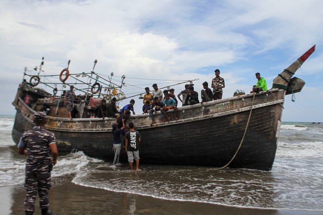 Personel TNI mengawal imigran etnis Rohingya yang terdampar di Desa Lampanah Leugah, Kecamatan Seulimeuem, Aceh Besar, Aceh, Kamis (16/2/2023). Foto: Ampelsa/ANTARA FOTO