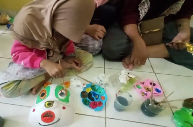 Anak dengan HIV AIDS sedang asyik melukis topeng. Foto-foto: Masruroh/Basra