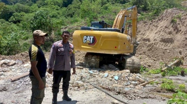 Keterangan foto:Tampak ekskavator dikerahkan ke lokasi longsor untuk memindahkan material longsoran. Foto: Humas Polres Kupang.