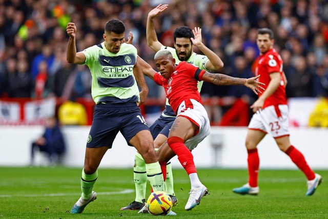 Pemain Manchester City Rodri beraksi bersama pemain Nottingham Forest Danilo di Stadion The City Ground, Nottingham, Inggris, Sabtu (18/2/2023). Foto: Action Images via Reuters/Peter Cziborra