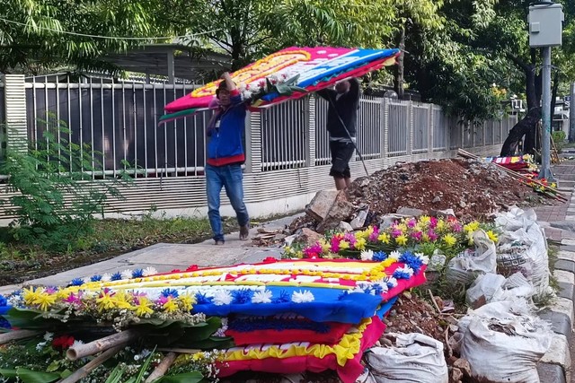 Karangan bunga Graha Pena 98, kantor persatuan aktivitas 98, yang mengular hingga Jalan Rasuna Said sudah mulai dibersihkan, Senin (20/2).  Foto: Hedi/kumparan