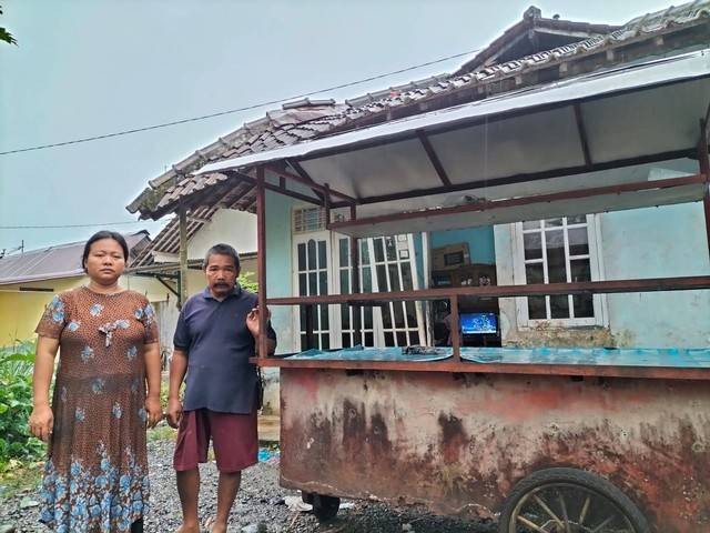 Ibu Riska, Susnensih, dan ayah Riska, Tekat Setiono, bersama gerobak tua yang dipakai berjualan setiap hari. Foto: Dok. Dompet Dhuafa Purwokerto