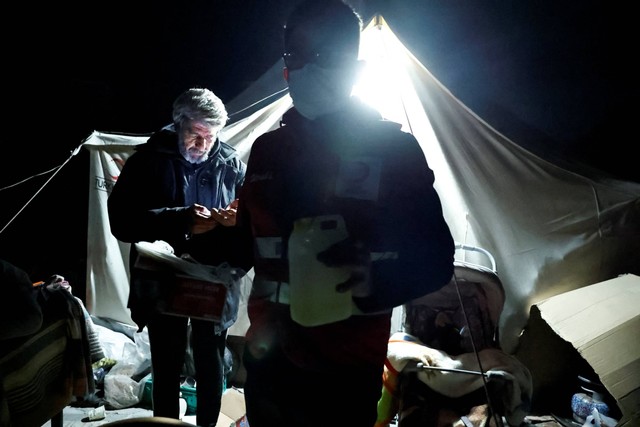 Orang-orang berjalan di luar tenda pengungsian setelah gempa bumi di Antakya di provinsi Hatay, Turki, Senin (20/2/2023). Foto: Clodagh Kilcoyne/REUTERS