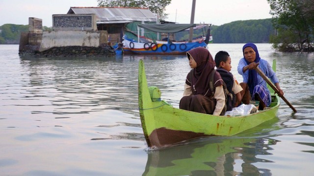 Mak Jah bersama Kodriyah dan adiknya tengah berangkat sekolah menggunakan perahu. Sumber: Dokumentasi pribadi