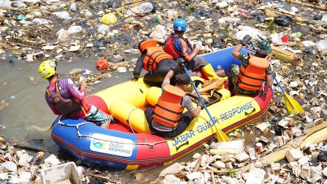 Aksi pemuda di Bandung turun ke sungai untuk membersihkan sampah yang tersangkut di bendungan di Sungai Cikeruh Bendungan, Kabupaten Bandung. Foto: Rachmadi Rasyad/kumparan