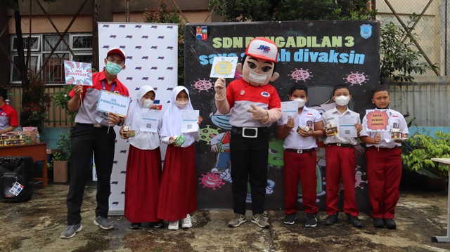 Siswa-siswi SDN Pengadilan 3 Kota Bogor berfoto bersama maskot JNE “JONI” setelah mendapatkan vaksin dosis pertama.