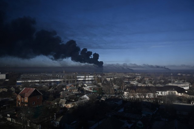 Asap hitam mengepul dari bandara militer di Chuguyev, Ukraina, pada 24 Februari 2022. Foto: Aris Messinis/AFP