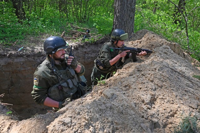 Prajurit Ukraina berdiri di lubang rubah Kharkiv, Ukraina, pada 30 April 2022. Foto: SERGEY BOBOK / AFP