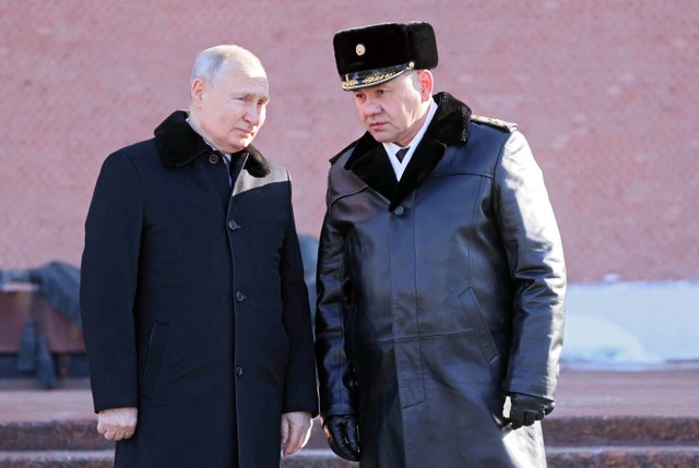 Presiden Rusia Vladimir Putin dan Menteri Pertahanan Sergei Shoigu mengambil bagian dalam upacara peletakan karangan bunga di Makam Prajurit Tak Dikenal oleh Tembok Kremlin pada Hari Pembela Tanah Air di Moskow, Rusia, 23 Februari 2023. Foto: Sputnik/Pavel Bednyakov/Kremlin via REUTERS