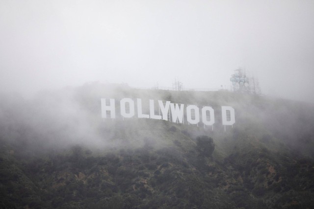 Tanda Hollywood terlihat melalui campuran kabut dan debu salju selama badai musim dingin yang langka di daerah Los Angeles, di Los Angeles, California, AS. Foto: Aude Guerrucci/REUTERS