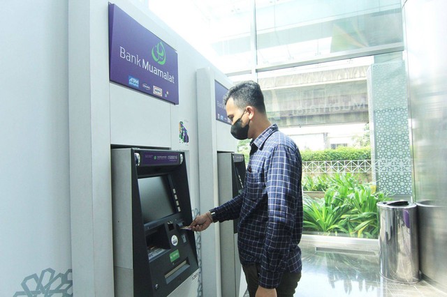 Nasabah PT Bank Muamalat Indonesia Tbk sedang bertransaksi menggunakan kartu debit Shar-E di mesin ATM Muamalat Tower. Foto: Bank Muamalat