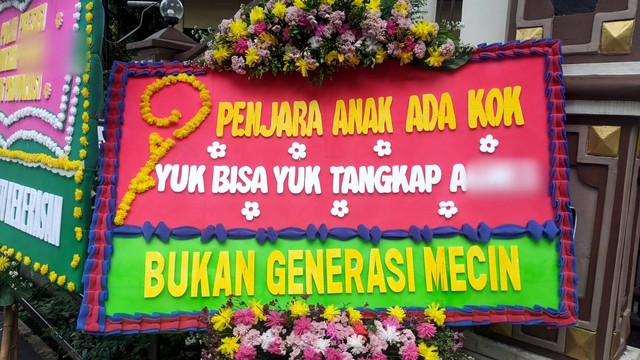 Sejumlah karangan bunga minta polisi tangkap perempuan A di kasus penganiayaan David terpasang di depan Mapolres Jaksel, Sabtu (25/2/2023). Foto: Jonathan Devin/kumparan