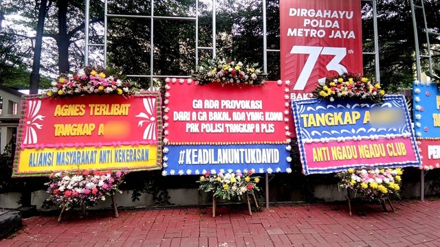 Sejumlah karangan bunga minta polisi tangkap perempuan A di kasus penganiayaan David terpasang di depan Mapolres Jaksel, Sabtu (25/2/2023). Foto: Jonathan Devin/kumparan