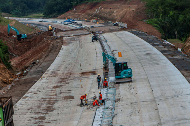 Pekerja menyelesaikan proyek pembangunan jalan tol Rangkasbitung-Panimbang seksi II di Lebak, Banten, Minggu (26/2/2023).  Foto: Muhammad Bagus Khoirunas/ANTARA FOTO