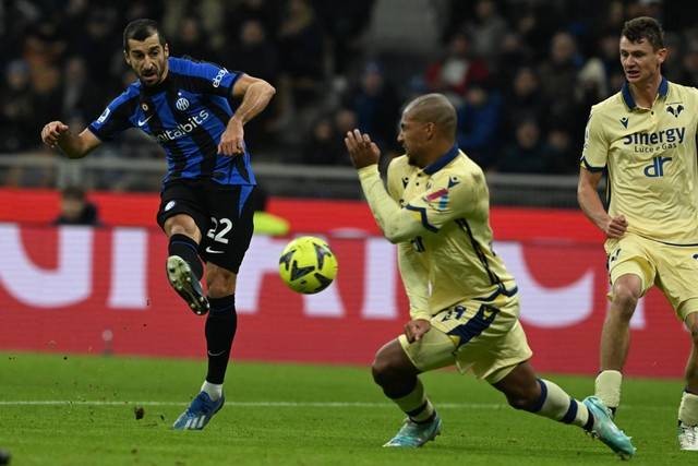 Pemain Inter Milan Henrikh Mkhitaryan menendang bola di depan pemain Hellas Verona Fabio Depaoli selama pertandingan sepak bola Serie A Italia Verona di stadion San Siro di Milan, Italia, Sabtu (14/1/2023). Foto: Miguel Medina/AFP