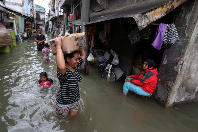 Sejumlah warga melintasi genangan banjir di Rawa Buaya, Cengkareng, Jakarta Barat, Senin (27/2/2023).  Foto: Prabanndaru Wahyuaji/ANTARA FOTO