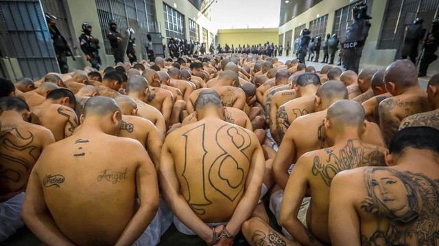 Para anggota geng menunggu digiring ke sel masing-masing. Mereka adalah bagian dari 2.000 anggota geng yang ditahan di Pusat Penjara Terorisme.