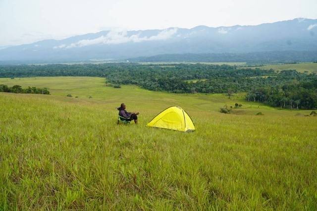 Seorang pria terlihat duduk disamping tendanya, sembari menikmati keindahan wisata alam Bukit Sontiri yang berada di Desa/Kampung Matatun, Distrik Kebar, Kabupaten Tambrauw, Provinsi Papua Barat Daya. Foto: Bertho Yekwam.