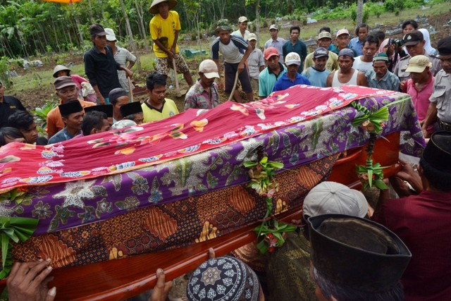 Kerabat dan penduduk desa menghadiri pemakaman Sumarti Ningsih, salah satu dari dua WNI yang dibunuh oleh bankir Inggris Rurik Jutting di Hong Kong, di desa Gandrungmangu, Cilacap, provinsi Jawa Tengah, pada 12 November 2014. Foto: Dida Nuswantara/AFP
