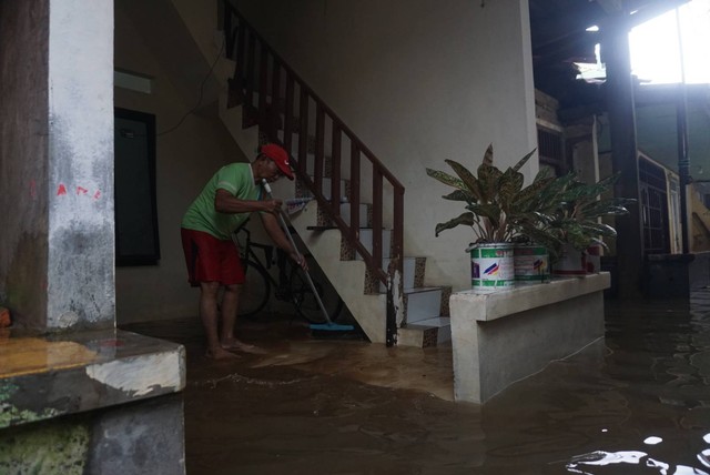 Ilustrasi warga membersihkan sisa-sisa banjir di Jakarta Selatan Foto: Iqbal Firdaus/kumparan