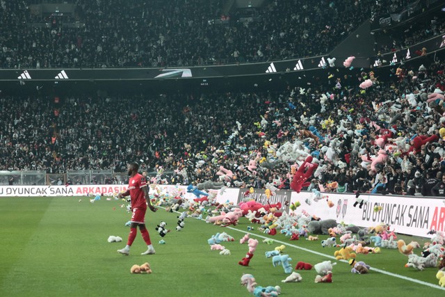 Fans melempar boneka ke dalam lapangan saat pertandingan Liga Super Turki antara Besiktas dan Antalyaspor di Vodafone Park di Istanbul, Turki, Minggu (26/2/2023).  Foto: Stringer/REUTERS