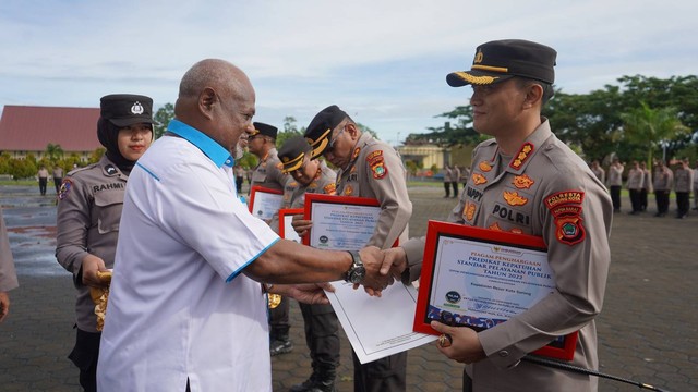 Kepala Ombudsman RI Perwakilan Papua Barat, Musa Y Sombuk menyerahkan piagam hasil penilaian pelayanan publik.