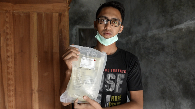 Eko Rahmat Saputro, ayah Raina menunjukkan larutan khusus, bagian dari 'cuci darah' anaknya.