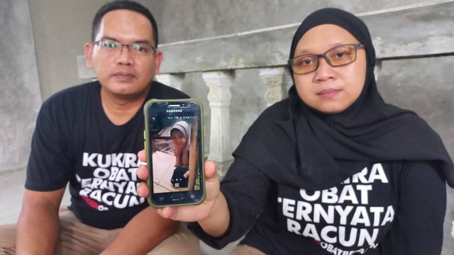 Asmari dan Nur Asiah menunjukkan foto putri mereka, Rahmaniah Anassya.