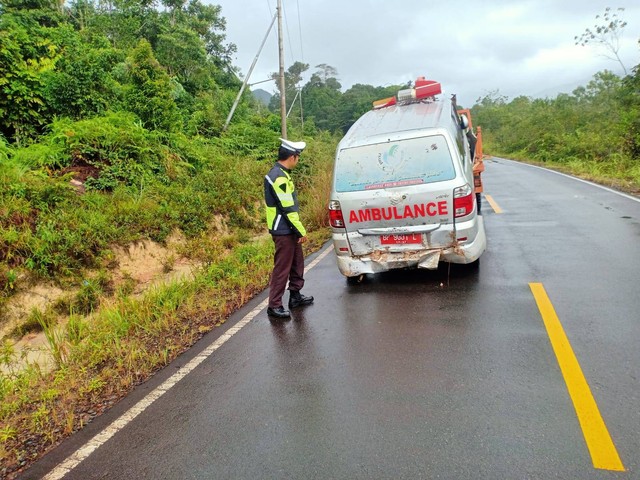Polisi membantu evakuasi ambulans yang tergelincir di jalan Sei Tenam, Lingga. Foto: Istimewa