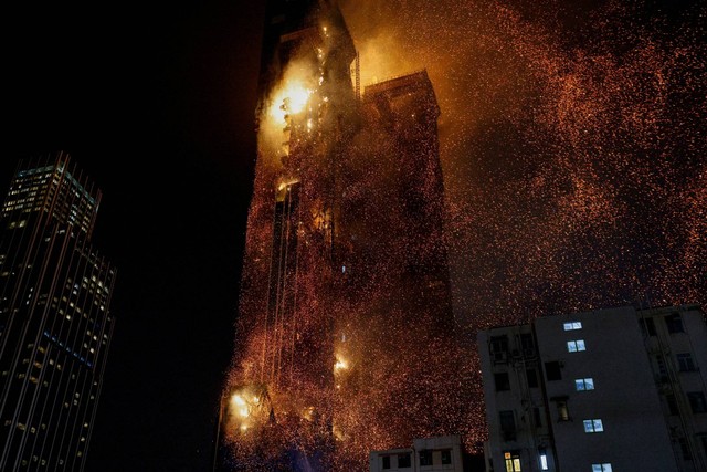 Sebuah bangunan terlihat terbakar di Tsim Sha Tsui, Hong Kong, China, Jumat (3/3/2023). Foto: Tyrone Siu/REUTERS