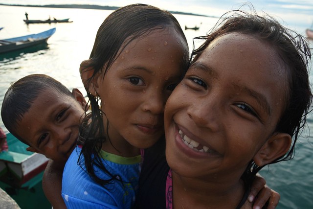 Tiga anak warga Suku Bajo berpose saat bermain air di Desa Mola Raya, Wang-Wangi Selatan, Wakatobi. Foto: Indrianto Eko Suwarso/ANTARA FOTO