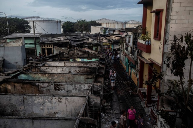 Sejumlah warga berada di dekat permukiman penduduk yang hangus terbakar dampak kebakaran Depo Pertamina Plumpang di Jalan Koramil, Rawa Badak Selatan, Koja, Jakarta, Sabtu (4/3/2023). Foto: Aprillio Akbar/ANTARA FOTO