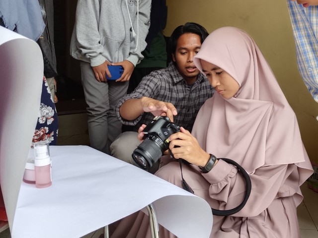 Salah satu mahasiswa UMM (kiri) mendampingi praktik peserta pelatihan dasar fotografi, Minggu (5/2/2023). Sumber: Dok. Pribadi.