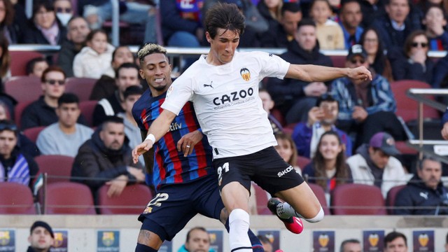 Raphinha (kiri) duel dengan Jesus Vazquez saat Barcelona melawan Valencia dalam pertandingan pekan ke-24 Liga Spanyol 2022/23 di Stadion Camp Nou pada 5 Maret 2023. Foto: REUTERS/Albert Gea