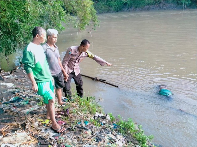 Polisi bersama warga mengevakuasi jasad pemancing yang ditemukan di Sungai Progo. Foto: Hermanto/Tugu Jogja