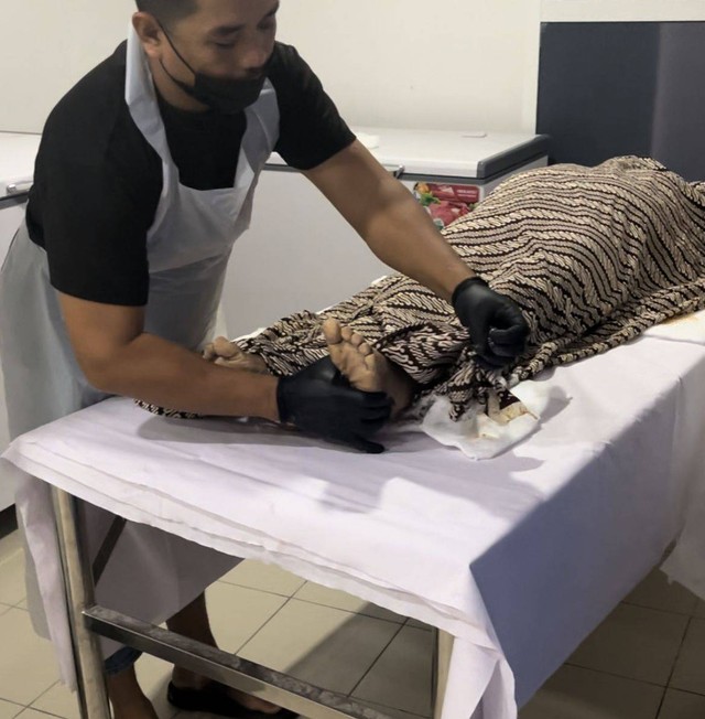 Foto proses pengafanan jenazah yang sudah di mandikan