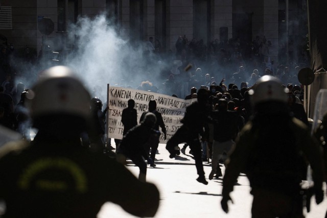 Para pengunjuk rasa bentrok dengan polisi saat demonstrasi usai tabrakan fatal dua kereta api, dekat kota Larissa, di Athena, Yunani, Rabu (8/3/2023). Foto: Alexandros Avramidis/REUTERS 
