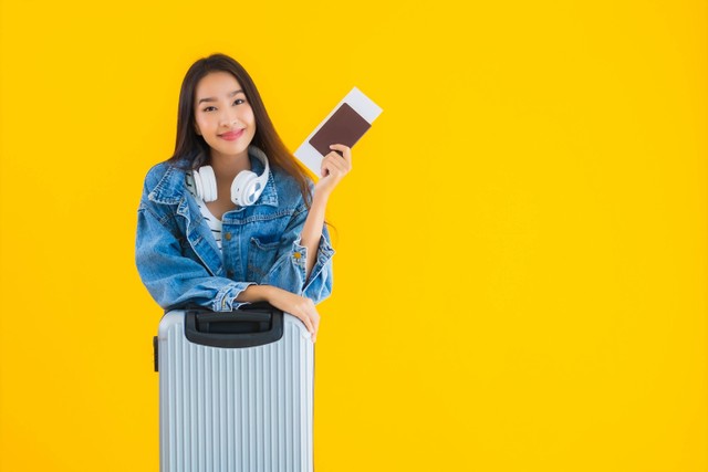 Ilustrasi perempuan traveling memegang boarding pass. Foto: Shutterstock