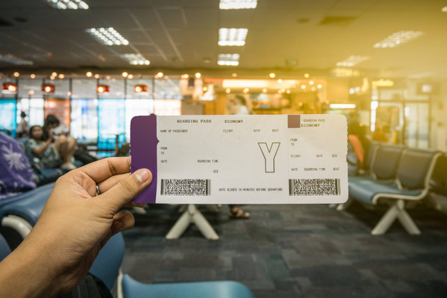 Ilustrasi pria memegang boarding pass. Foto: Shutterstock